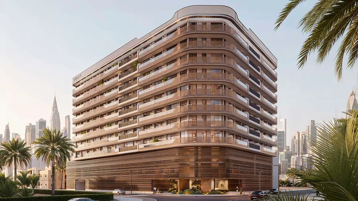 Un moderno edificio de Dubai con ventanas panorámicas y palmeras contra el paisaje urbano.