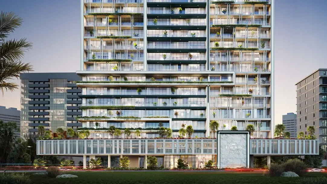 Un moderno edificio de apartamentos con vegetación en los balcones y un cielo azul.