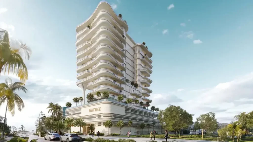 Un bâtiment moderne avec des balcons ondulés, entouré de palmiers et d'un ciel radieux dans un paysage urbain.