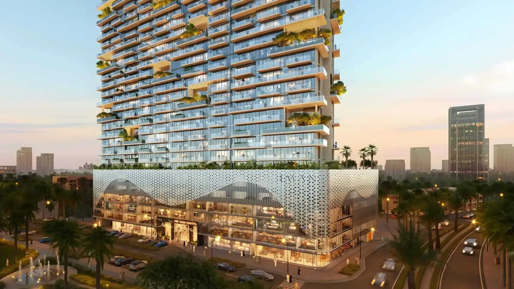 A modern urban skyscraper with green terraces against the backdrop of the city in the evening.