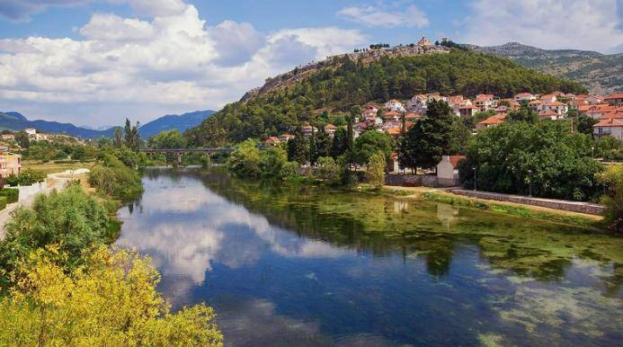 Landschaft von Serbien mit Text über Steueranreize für ausländische Investoren, Spiegelung eines Berges in einem Fluss.