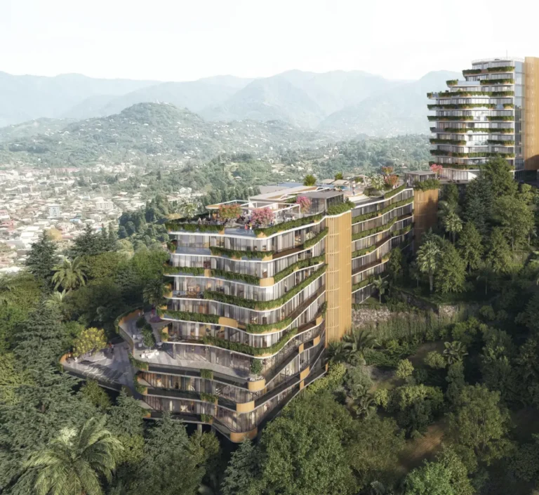 A modern high-rise amidst greenery against a mountainous backdrop, with terraces and roof gardens.