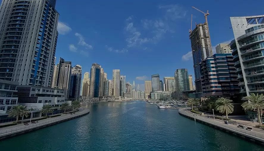 Moderne wolkenkrabbers langs het kanaal in Dubai bij helder weer, weerspiegeling in het water.