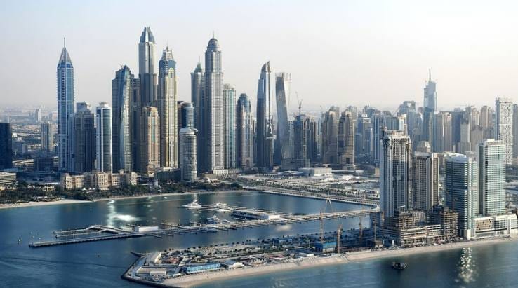 Dubai panoraam koos tekstiga välismaalase kinnisvara ostmise kohta AÜEs, vaade merele ja pilvelõhkujatele.