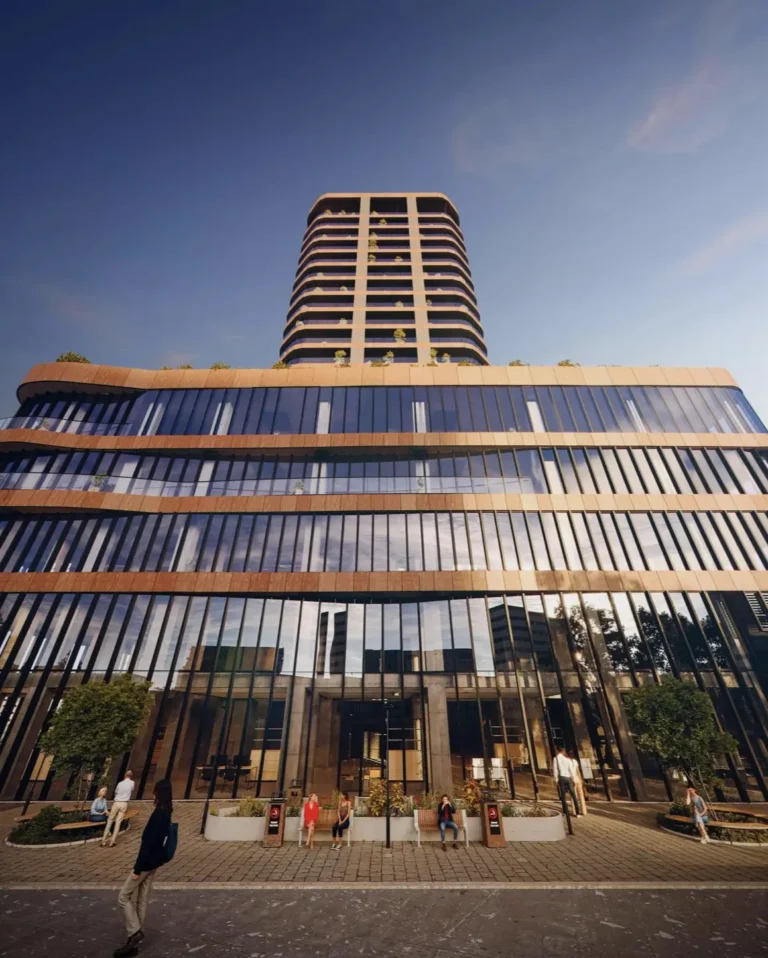 A modern high-rise building with large glass facades against a clear sky.