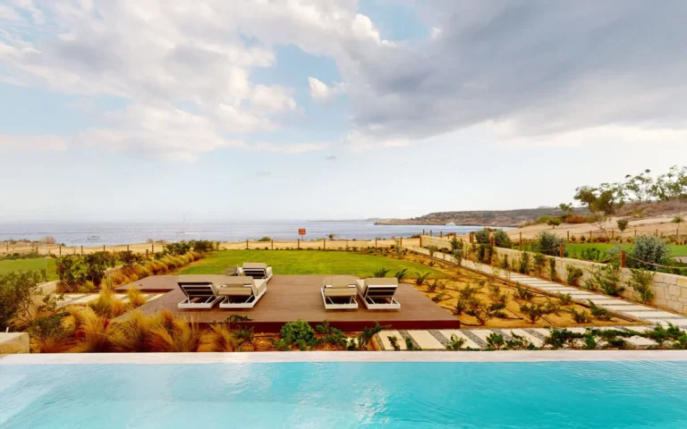 El paisaje con la piscina y las tumbonas junto al mar al fondo, dan un ambiente tranquilo.