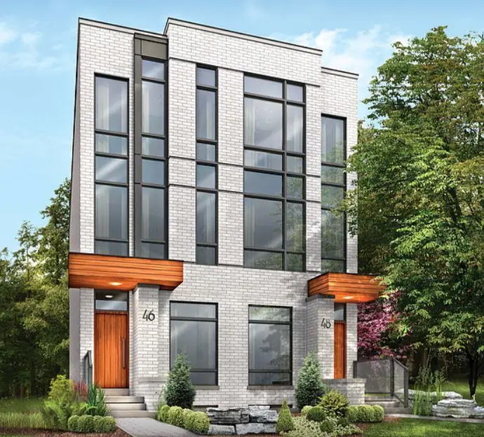 Modern three-story house with large windows and trees all around, sunny day.