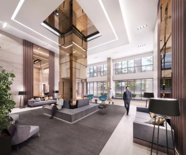 Modern interior of the business center lobby with high windows and stylish furniture.