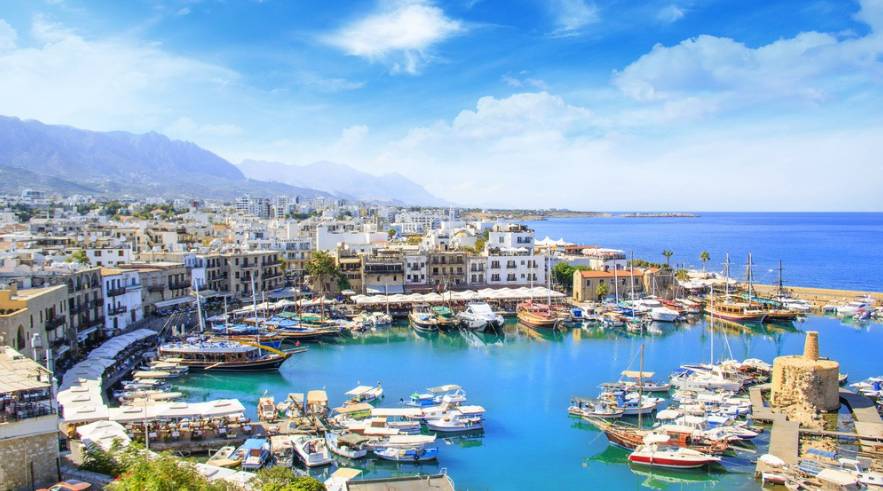 Image with text: Property changes in North Cyprus against the backdrop of a picturesque port with boats.