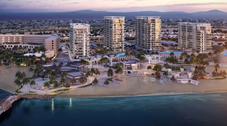 Una moderna estación balnearia con altos edificios, piscinas y playa, rodeada de palmeras y mar.