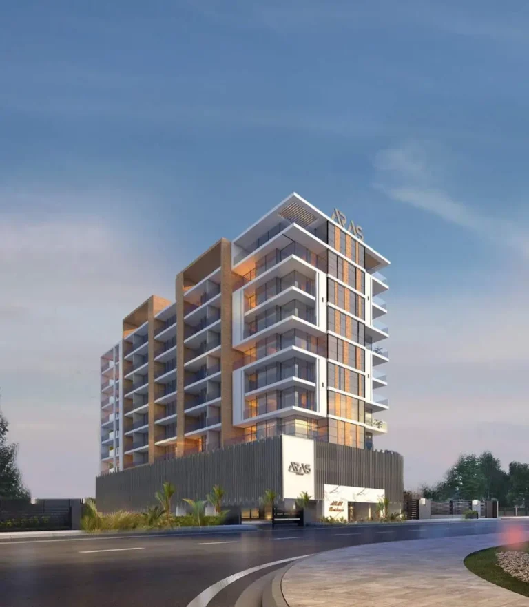 A modern residential building with balconies and glass facade against a clear sky.