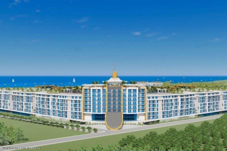 Moderno complesso residenziale sul mare con vista panoramica e terrazze verdi.