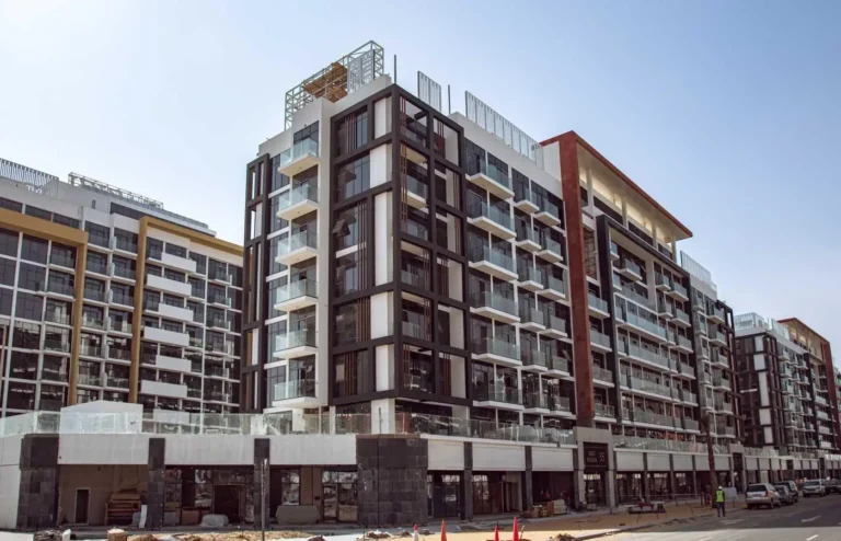 Modern apartment buildings with balconies against a clear sky.