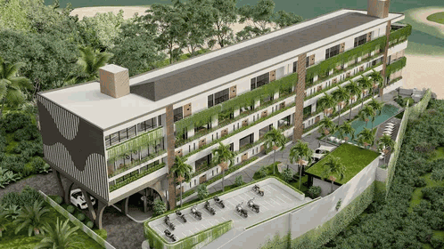 Un moderno edificio de varias plantas con fachadas verdes rodeadas de vegetación tropical.