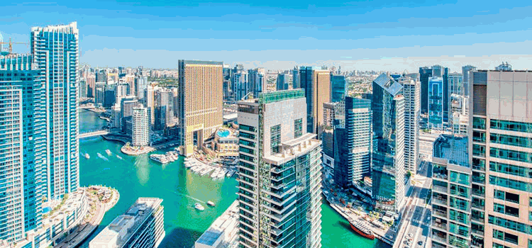 Modern high-rises and the canal in the Dubai Marina neighborhood in bright daylight.
