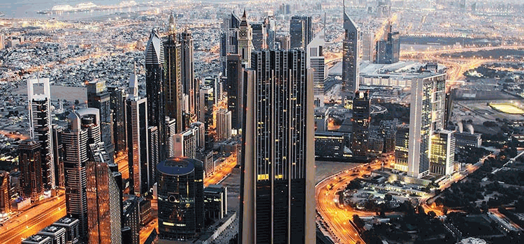 Vista nocturna de los modernos rascacielos de Dubai iluminados con luces.
