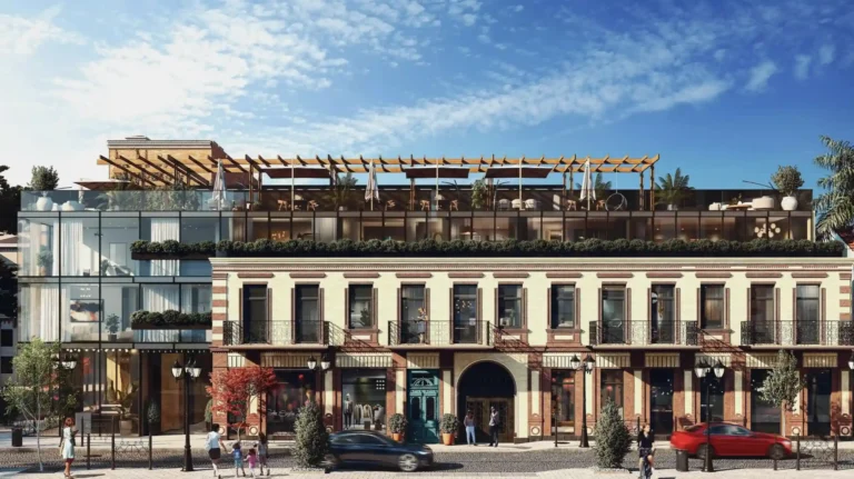 A modern building with a roof terrace and stores, people walking on the street, cars on the road.